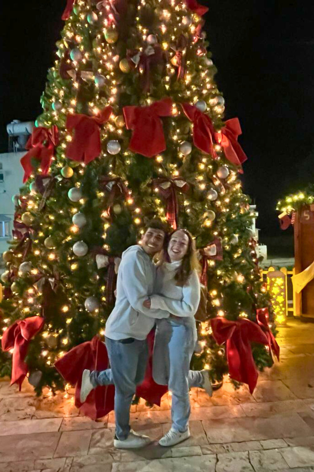 couple by a giant outdoor christmas tree