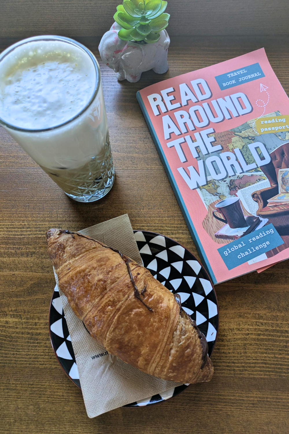 read around the world journal with a coffee and croissant